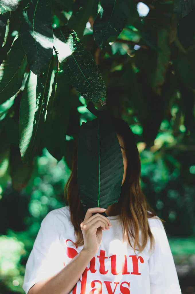 woman holding leaf face woman holding leaf face